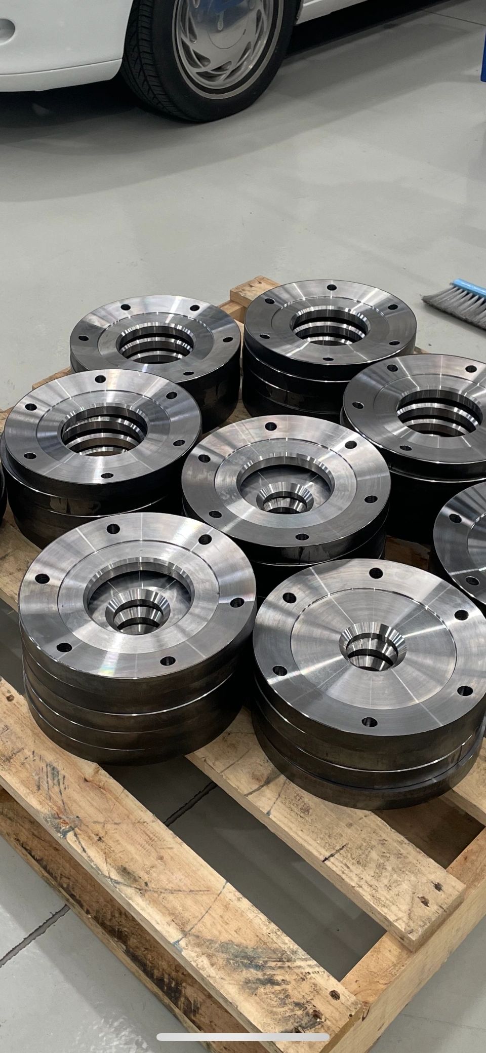 Polished steel wheel hub flanges on timber pallet, automotive machining