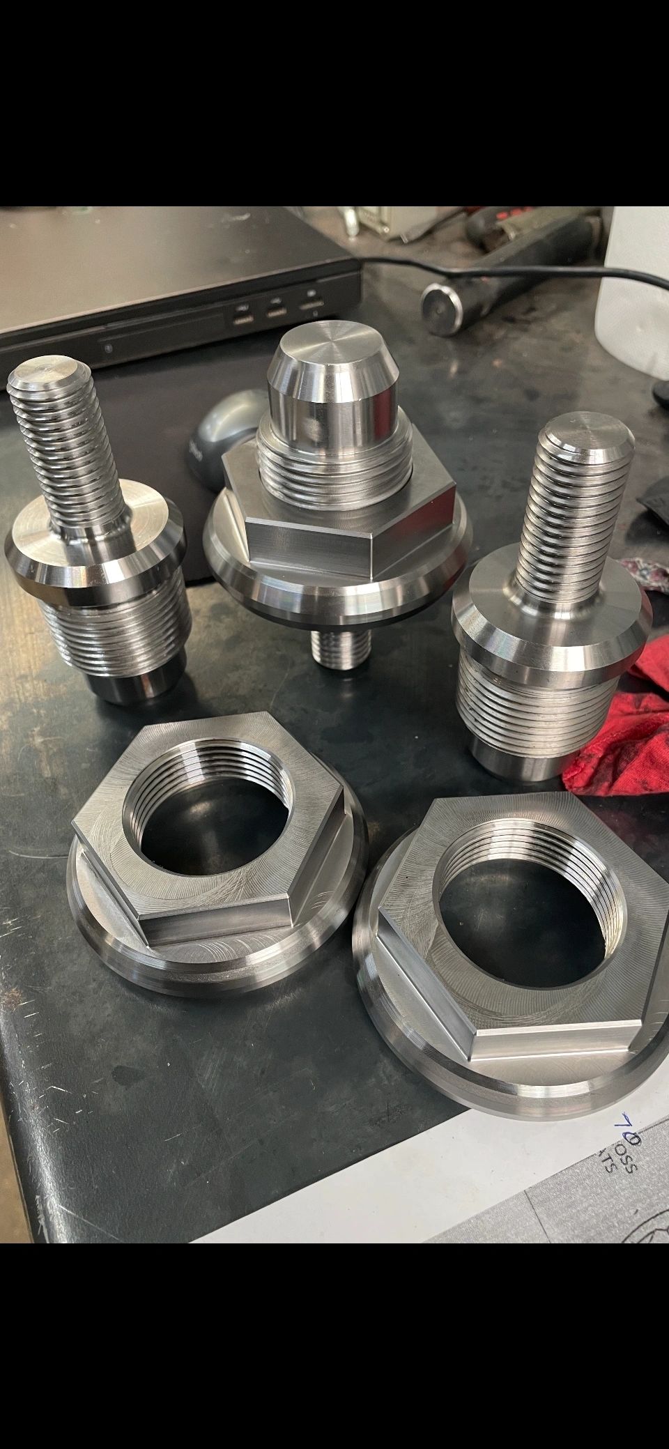Threaded studs and large hex flange nuts on workbench