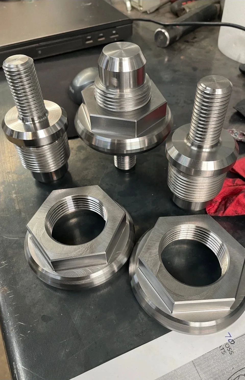 Threaded studs and large hex flange nuts on workbench