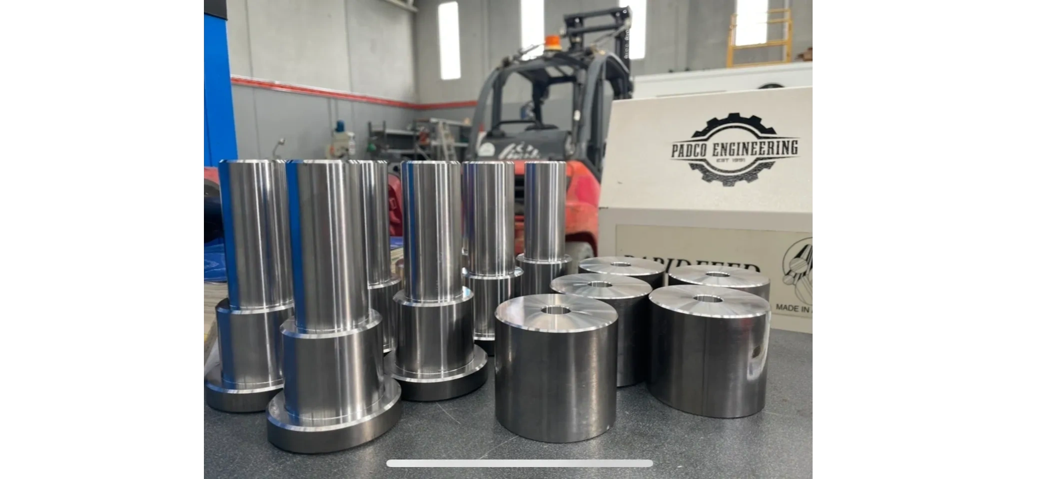 Padco Engineering workshop sign with production parts on workbench