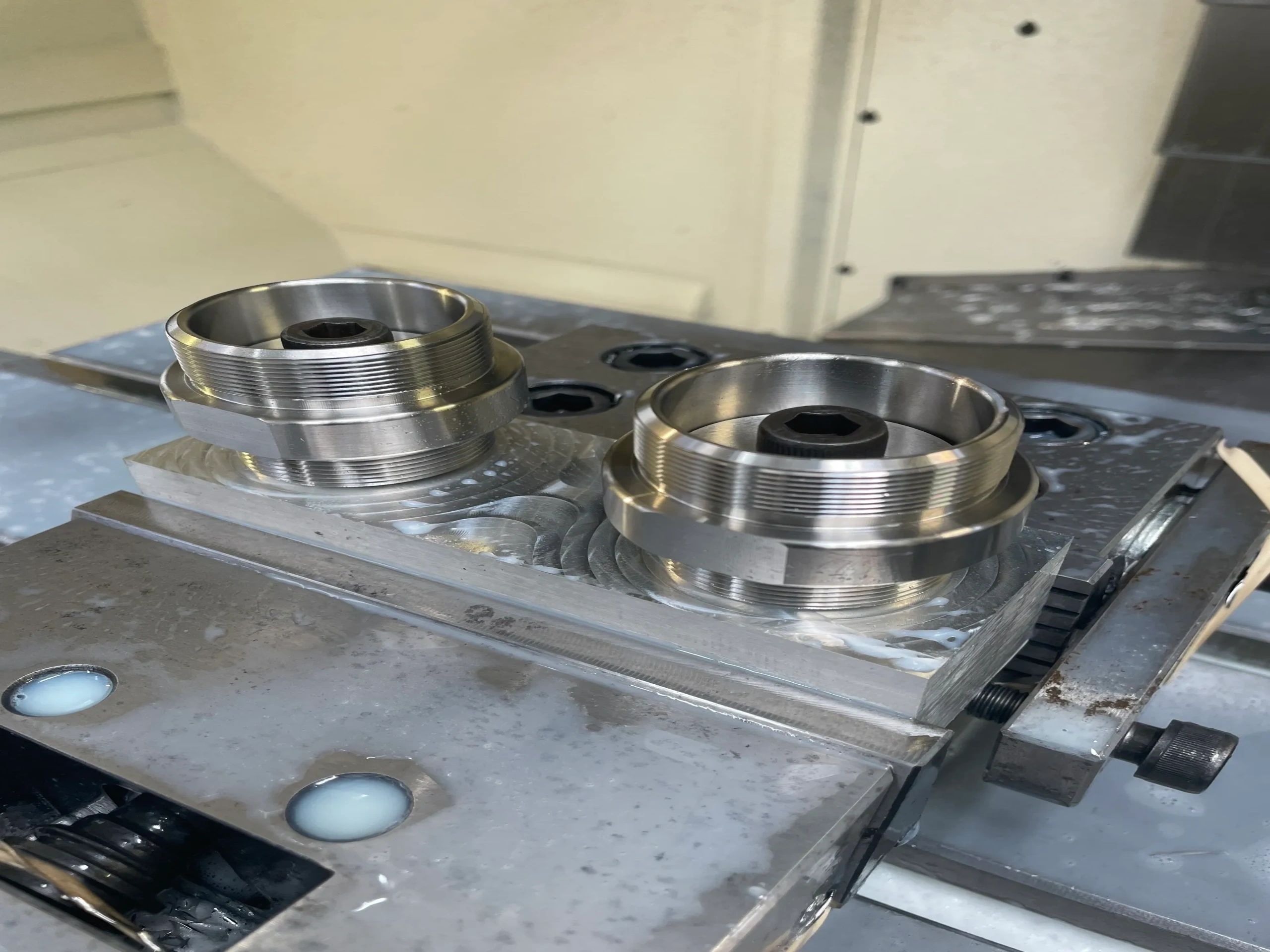 Threaded disc parts mounted on milling vise during CNC milling