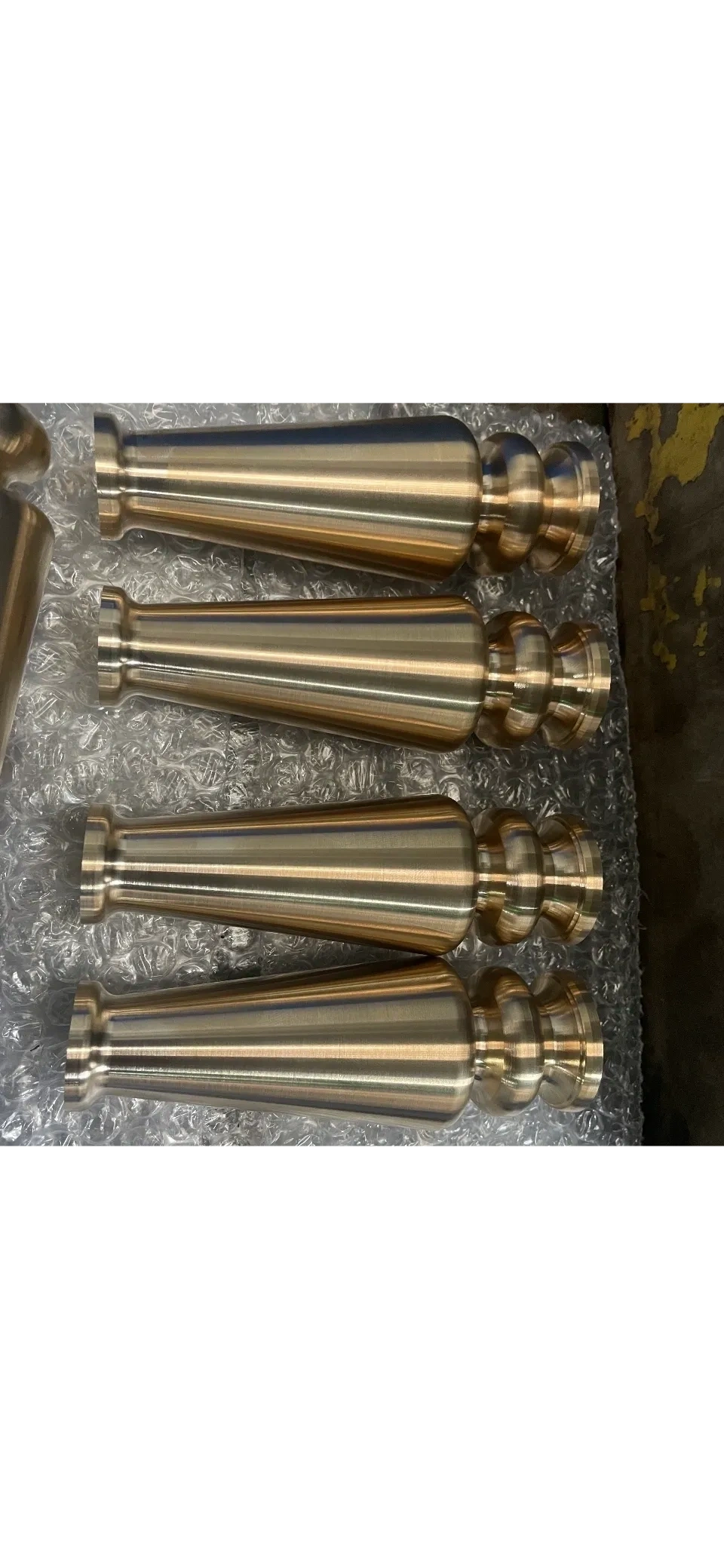 Batch of tapered brass-finish shafts with multi-step heads