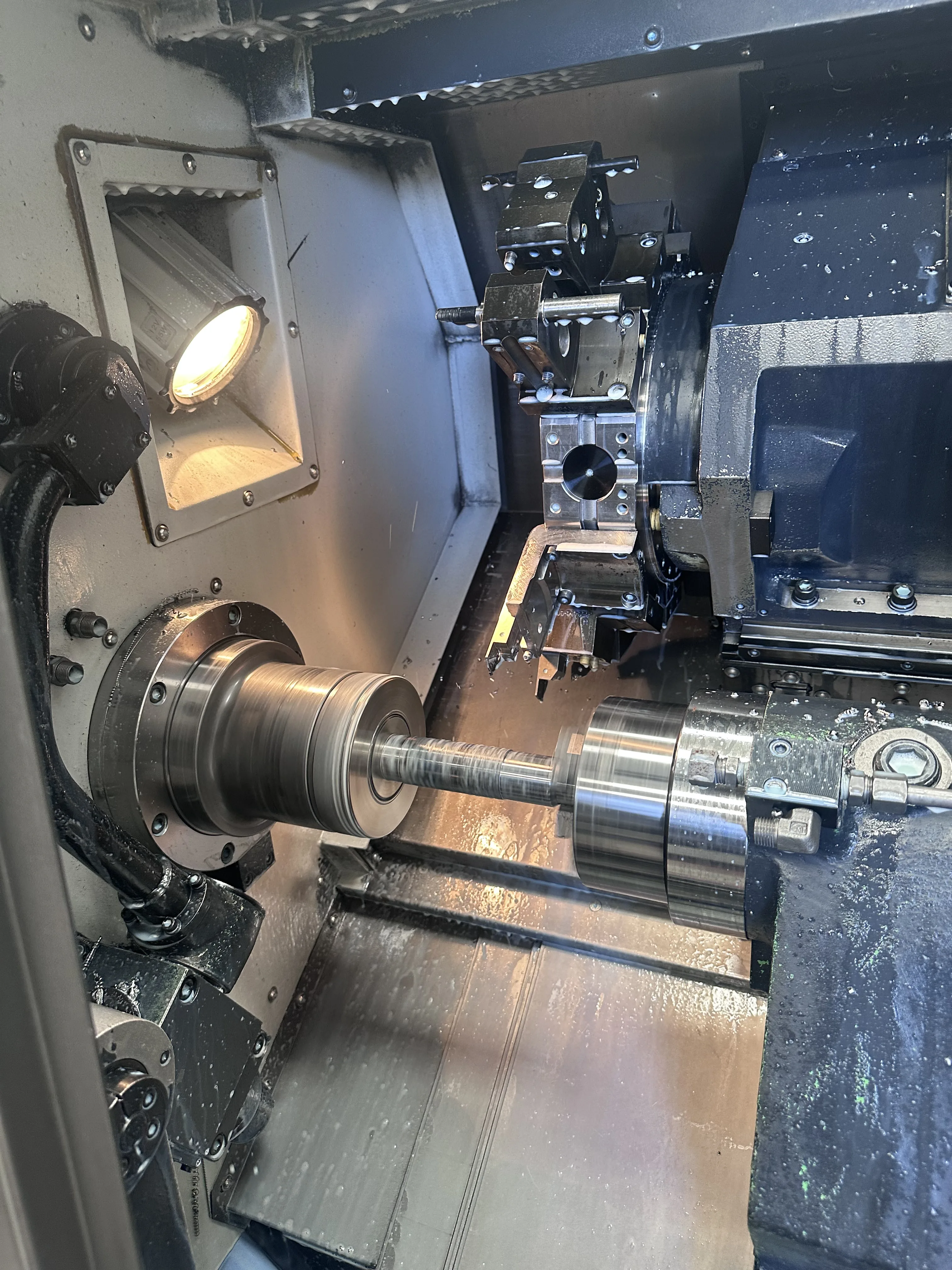 CNC lathe interior during operation — chuck, sub-spindle and live tooling, Padco Engineering